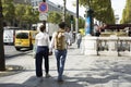 French people boyfriend and girlfriend walking hand in hand on walkway at sidewalk in LÃ¢â¬â¢avenue des Champs-Elysees